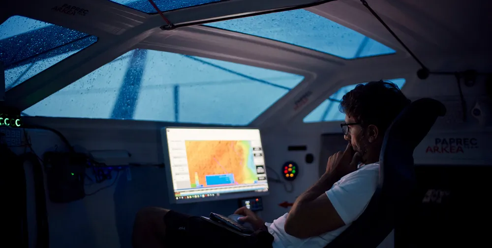 Yoann Richomme working on the weather aboard Paprec Arkéa