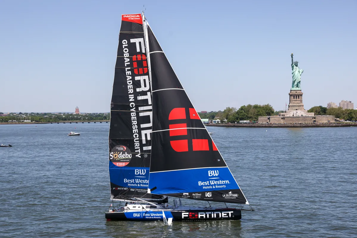 Imoca Fortinet - Best Western est photographié devant la Statue de la Liberté lors de la course Liberty Race à New York, USA