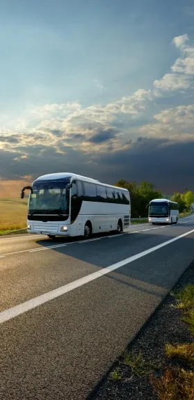 Deux bus roulant sur une route de campagne